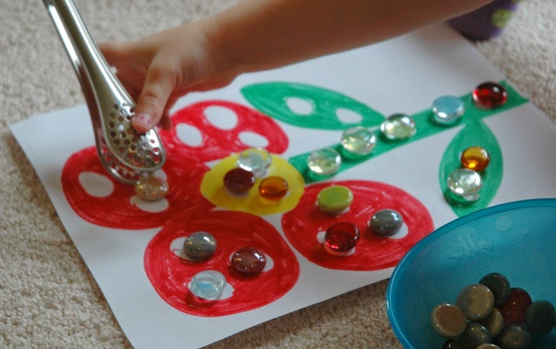 transferring marbles with tongs for flower theme week