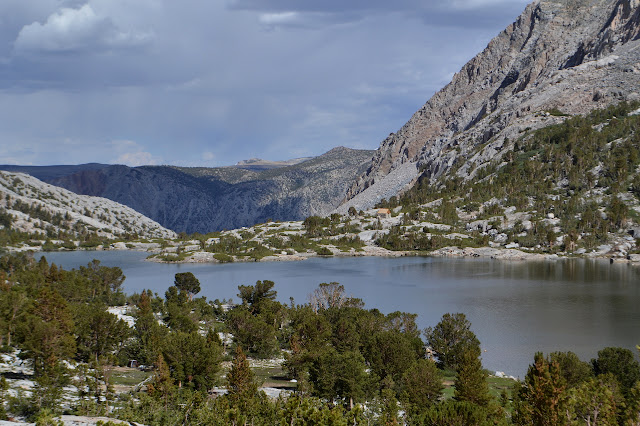 large lake with sparse trees and a cabin