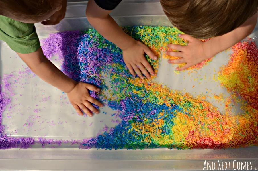 Playing with rainbow dyed shredded coconut - colorful, scented sensory play from And Next Comes L