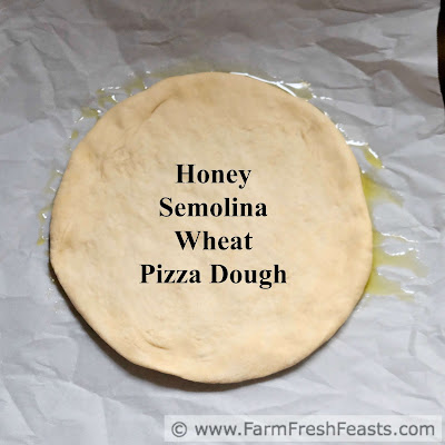 this pizza dough uses honey, semolina flour for crunch, and some whole wheat for nutrition and flavor