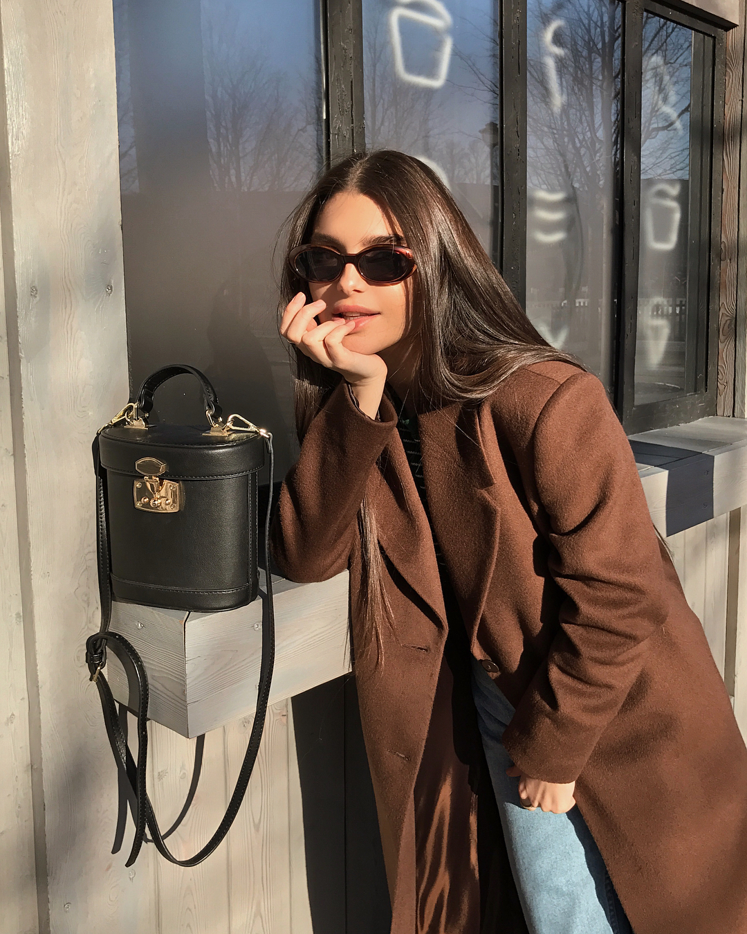 25 Stylish Brown Coats and Jackets for Your Fall and Winter Outfits — @mariecher Maria Chervotkina in a brown coat, Mark Cross top-handle bag, classic jeans, and oval sunglasses