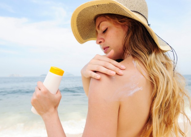 woman applying sunscreen lotion 