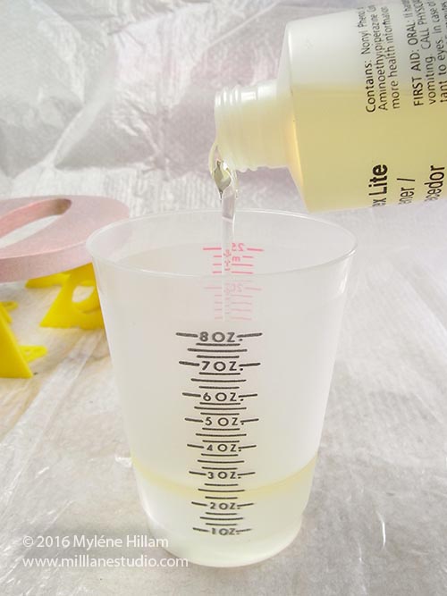 Pouring out the resxin into a graduated measuring cup.
