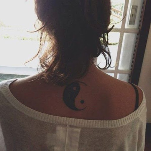 Um simples e clássico, Yin, Yang, tatuagem com tinta sobre a peça de base do pescoço. Perfeito para quem gosta de design original e gostaria de colocá-lo em um lugar onde eles podem convenientemente cobri-lo.