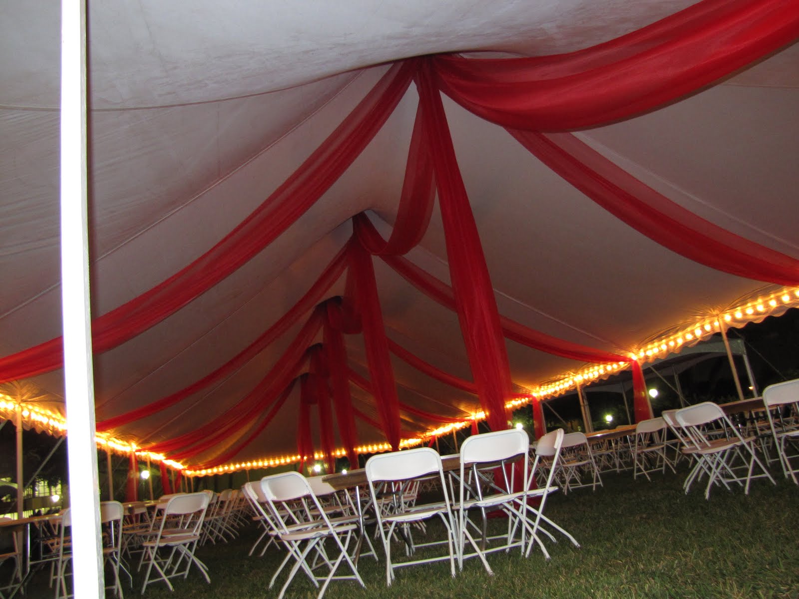 Party People Event Decorating Company Tent Organza Swags at night time.