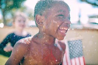 Image: Happy boy laughing in sprinkler, by StockSnap on Pixabay