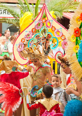 6 Canary Island Festivals You Should Check Out woman with a huge feathered headdress on.