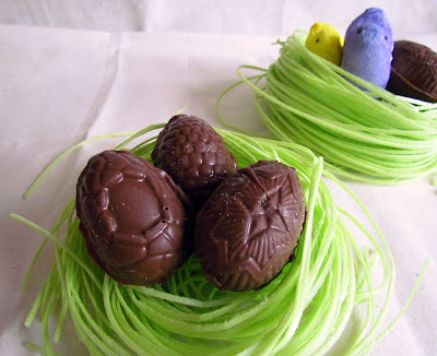 chocolate easter eggs on grass with PEEPS behind