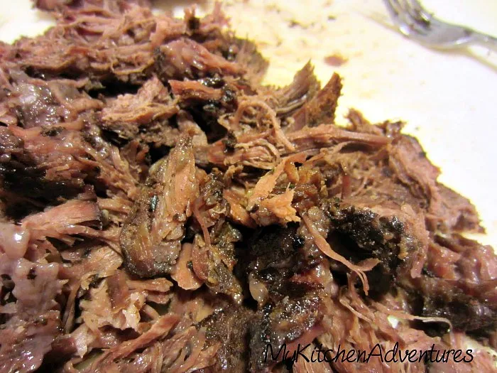 Slow Cooker BBQ Beef shredded on a white cutting board. 