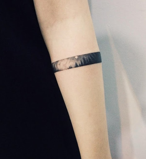 As meninas também poderia ir com a floresta tatuagens e aqui está uma encantadora e única maneira de fazê-lo. É uma pequena paisagem de uma floresta à noite, concebido como uma braçadeira.