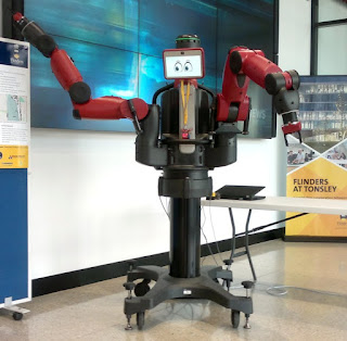 The robot has wheels at the base with red robot arms that moved. The screen is at the top and has graphic images of cartoon eyes to emulate a face.  The arms move to give directions and the robot 'talks'.