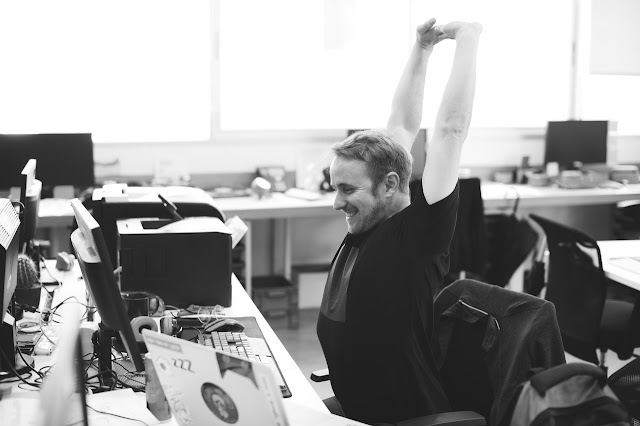 Man stretching at his desk, taking a break