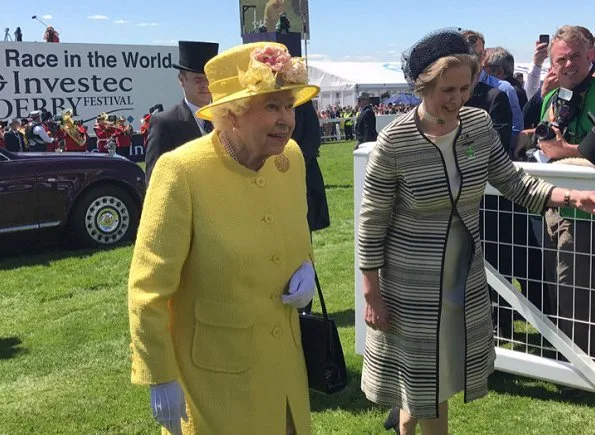 Queen Elizabeth arrived at the Epsom Derby in Surrey wearing a yellow coat, matching hat and flowery dress, holding a black bag