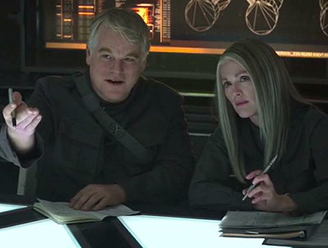 Plutarch Heavensbee (Philip Seymour Hoffman) y Alma Coin (Julianne Moore) en Los juegos del hambre. Sinsajo parte 1 - Cine de Escritor Plutarch Heavensbee (Philip Seymour Hoffman) y Alma Coin (Julianne Moore) en Los juegos del hambre. Sinsajo parte 1 - Cine de Escritor