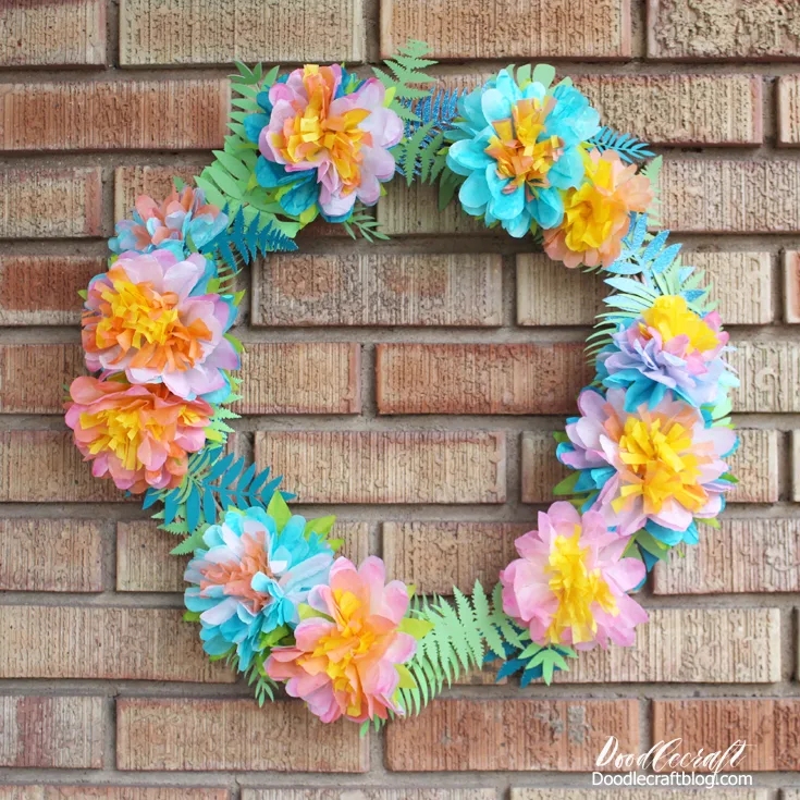 Tropical paper fronds decorating a wreath with coffee filter flowers
