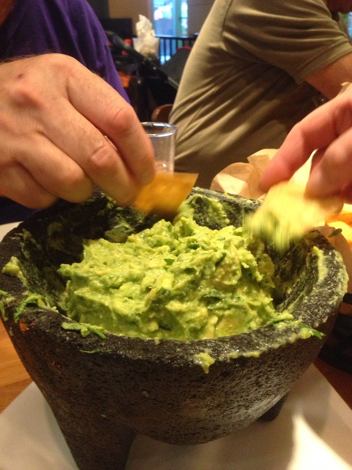 people dipping chips into guacamole at a party