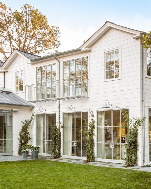 White modern farmhouse exterior with steel windows by Giannetti Home
