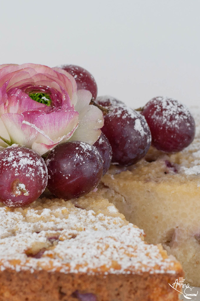 Ranunkel und Weintrauben auf Weintrauben-Couscous-Kuchen Ranunkel und Weintrauben auf Weintrauben-Couscous-Kuchen