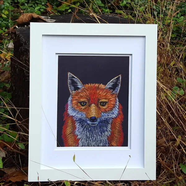 print of an original pastel fox illustration in white frame with woodsy background