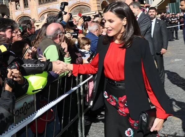 Queen Letizia wore Zara cape style jacket in black and Hugo Boss Banora gathered silk blouse in red. diamond earrings