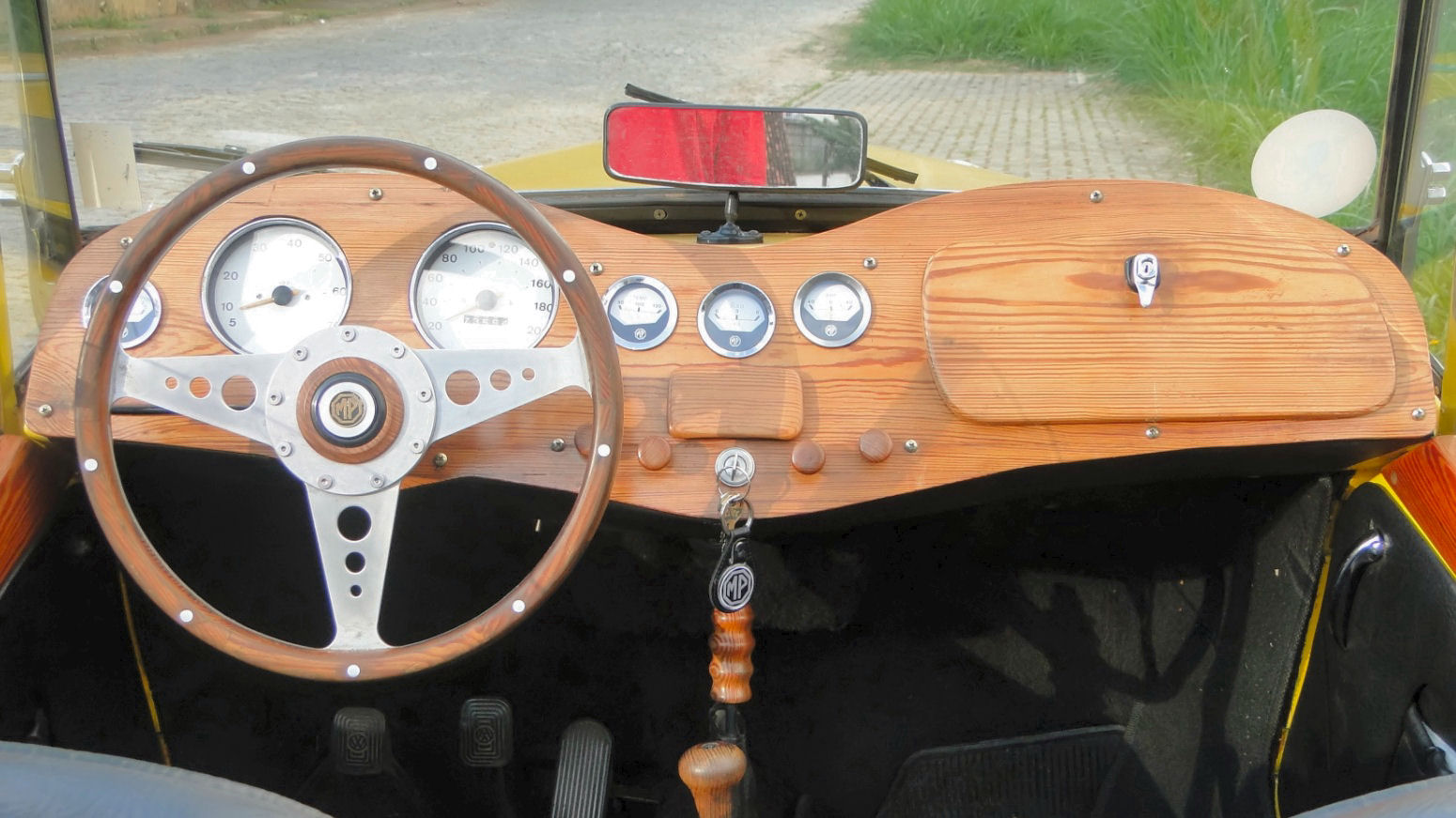 O painel de madeira é personalizado, assim como o volante de três raios, de uma elegância e esportividade impecável.