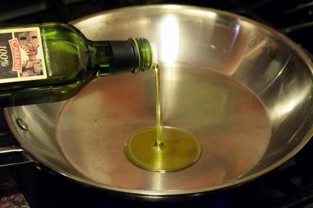 Olive oil being added to a skillet. 