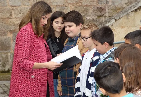 Queen Letizia wore Uterque Black leather pants and Uterque red coat. Queen Letizia wore Carolina Herrera black patent and suede pumps