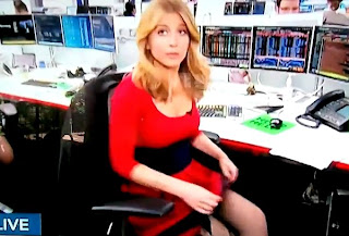 rubia reportera con vestido rojo y la falda levantada y un consolador en vivo en television