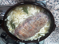 Cocinando el lomo relleno con la cebolla y el caldo.