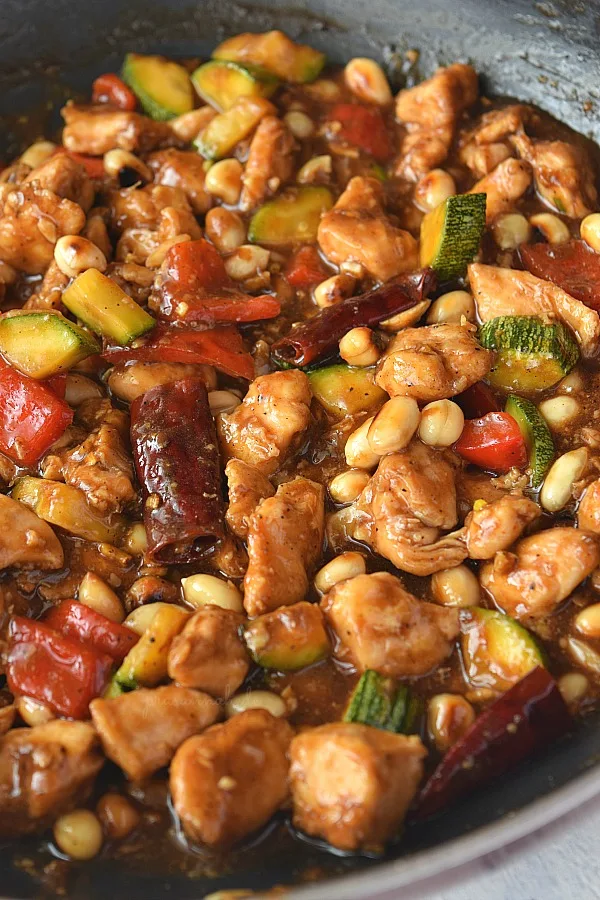 close look of delicious kung pao chicken with bell pepper,zucchini,peanuts and chicken tossed in sauce