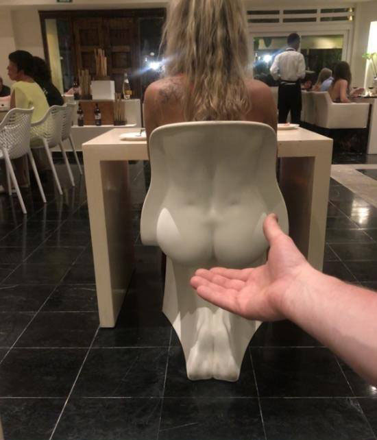 Witzige Bilder Frau auf lustigem Stuhl im Restaurant