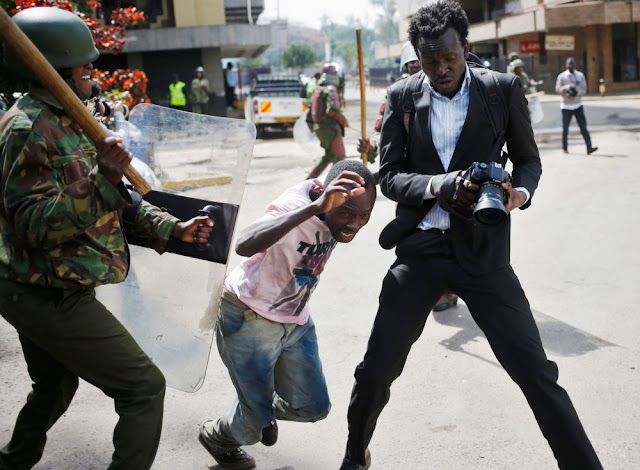 A Kenyan policeman beats a protester during clashes in Nairobi, Kenya. May 16.