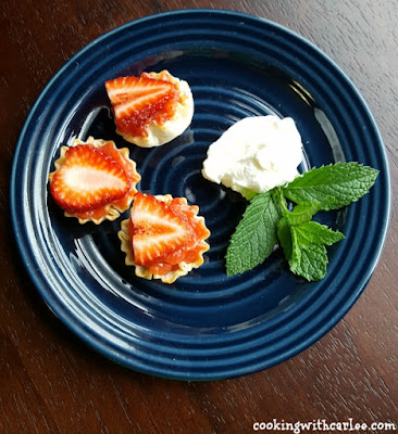 strawberry tarts on plate with mint and whipped cream