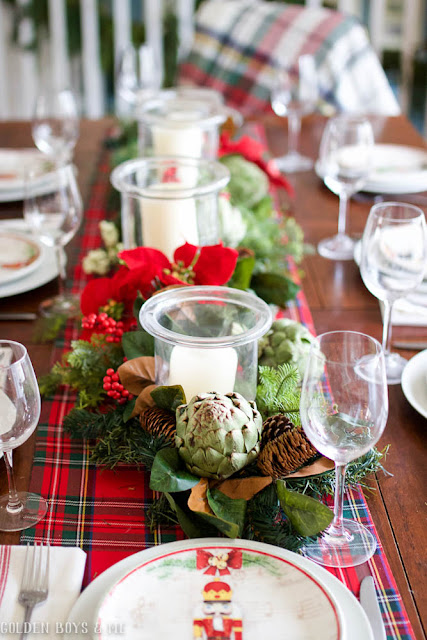 Classic Chrisrmas dining table setting with plaid runner, garland and fresh artichokes