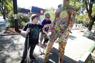 Michael May, right, CEO of Sendero Group, and William Jeffries of Roseville reach the a statue at Fourth and G streets Saturday morning on a scavenger hunt in downtown Davis. Image copyright Davis Enterprise.