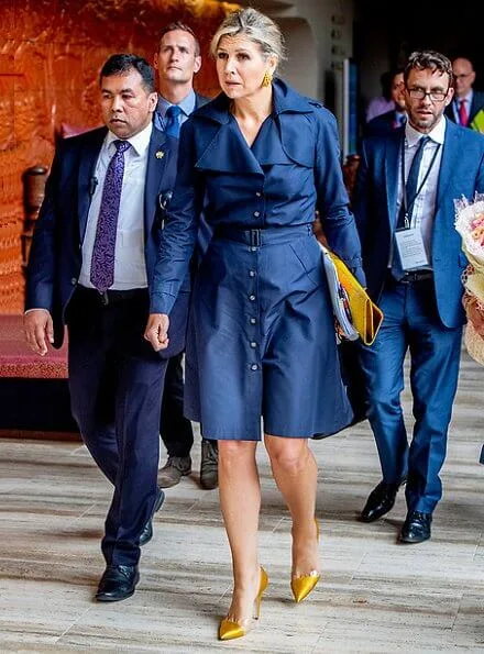 Queen Maxima wore a navy blue trench dress by Jan Taminiau. yellow earrings and Gianvito Rossi yellow metallic pumps