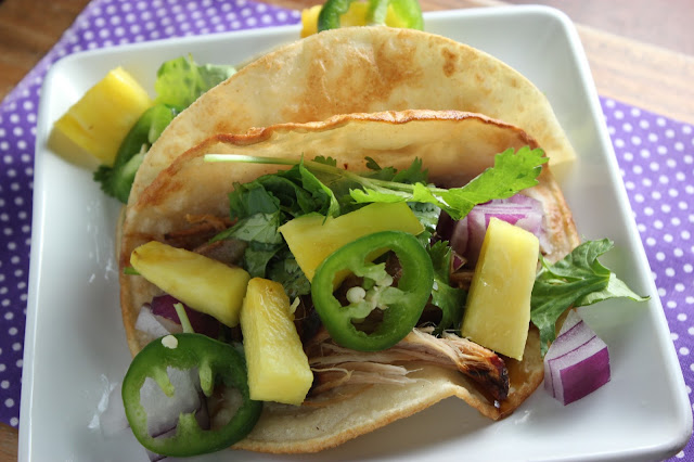 Slow cooker teriyaki pork tacos. Perfect for Taco Tuesday.  Easy and delicious.  Topped with Pineapple, cilantro, red onions and jalapenos and drizzled with teriyaki sauce.
