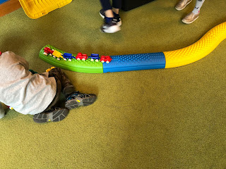 child playing with toy cars on top of tactile path