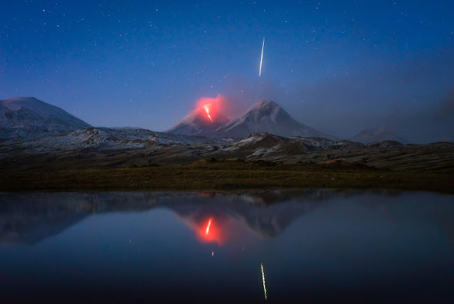 赤く怪しく噴火する火山と流れ星のコラボの幻想的な写真