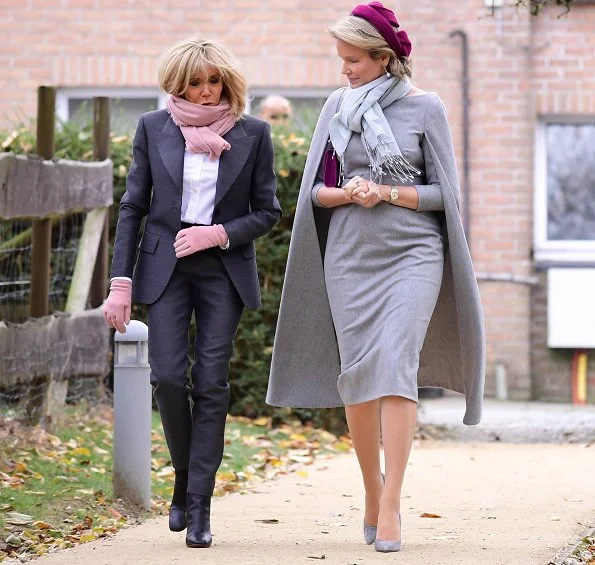 President Emmanuel Macron. First Lady Brigitte Macron is waring grey suit, and Queen Mathilde wore Merino wool cape dress