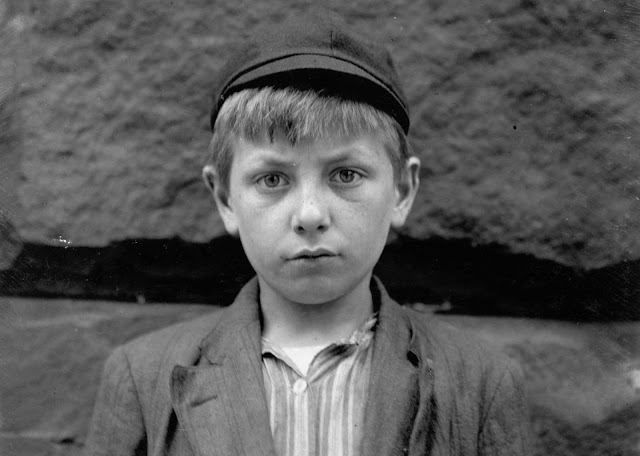 Louis Birch, age 12, a newsboy, stands at the corner of 4th and Pine St in Wilmington, Delaware, in May of 1910. Louis had just started selling, earning 10 cents in a day. His father had passed away. Louis, of his own accord, took up newspaper selling in order to help support his widowed mother. Louis stays out until 12:30 every night and accompanies his brother, Stanley, who is a messenger, on all calls because Stanley is afraid to be out on the street alone at night.