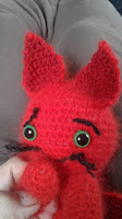 Picture shows a little red baby dragon with green eyes, close up of the face, the face expression is sorrowful, concerned, but looking very cute.