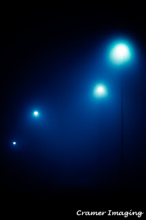 Cramer Imaging's professional quality fine art photograph of four blue-toned street lights in the dark and fog of Pocatello, Bannock, Idaho