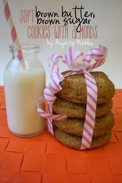 A stack of soft brown butter, brown sugar cookies with almonds with a glass of milk from www.anyonita-nibbles.com