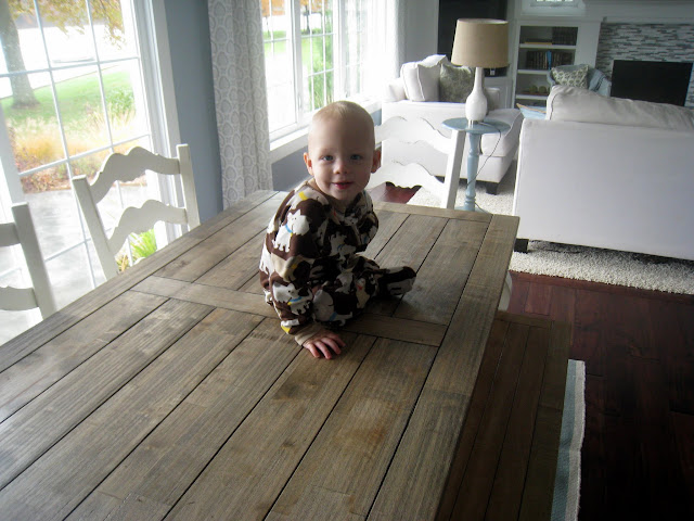 A little boy sitting on a wooden table
