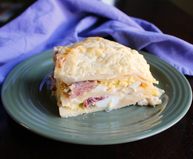 Croque madame inspired lasagna is perfect for breakfast, brunch or dinner. Bonus: it's also a great way to use leftover ham and hard boiled eggs from Easter! close up slice of croque madame lasagna with layers of cheese, white sauce, eggs and ham