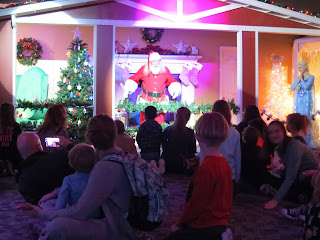 Santa Claus and Else entertain a crowd of children and parents at the Omaha Children's Museum Santa's Magic exhibit