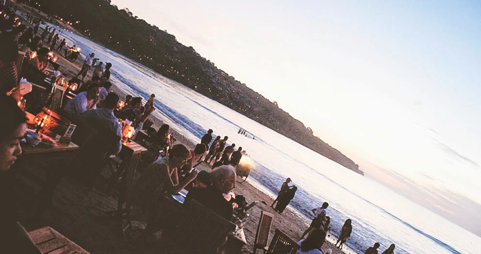 Nomaden digital bekerja di kafe dengan pemandangan pantai