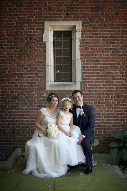 bride and groom with flower girl in front of brick wall des moines bride and groom with flower girl in front of brick wall des moines