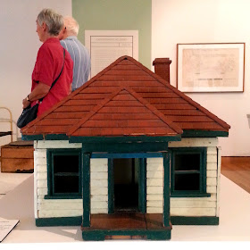 1930s vintage dolls' house bungalow on display in a museum gallery.